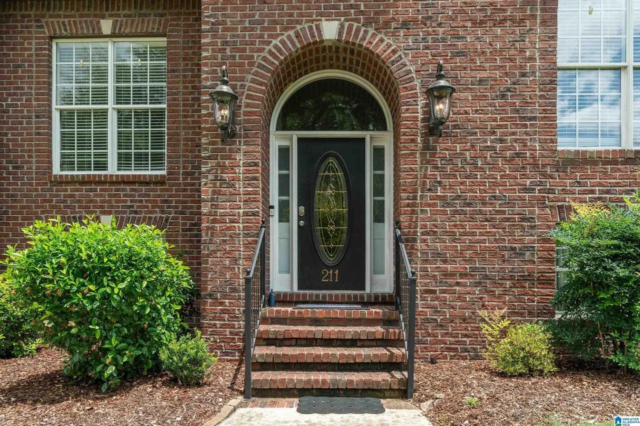 Arched brick entry with leaded glass front door