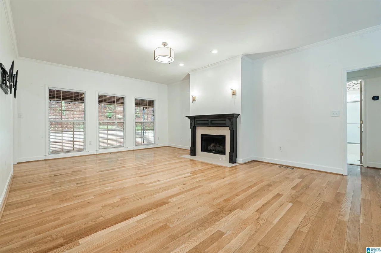 Living room with hardwood floors, fireplace and a wall of windows